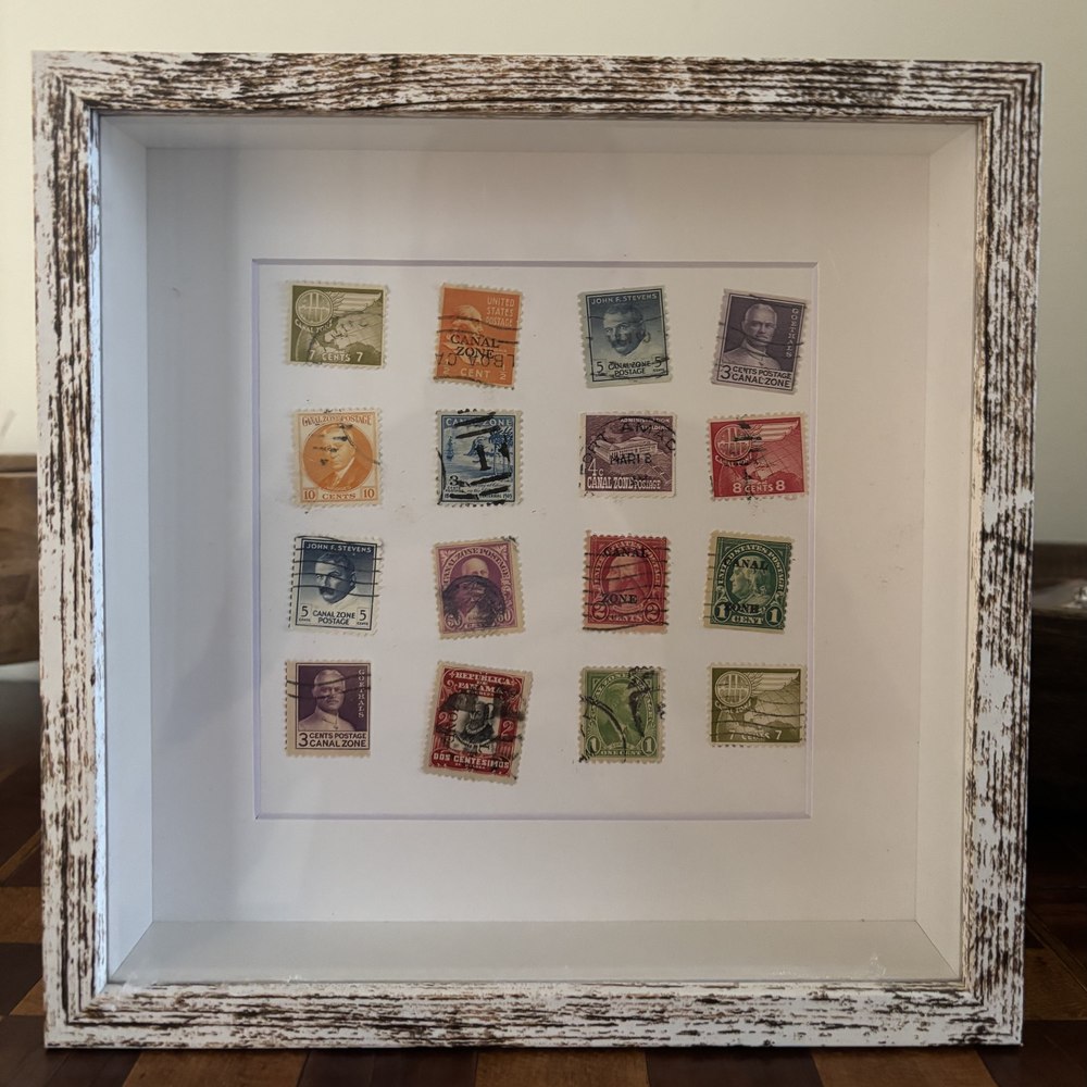Panama Canal Redux framed postage stamp art — vintage Canal Zone and overprint stamps in a weathered white 8x8 shadow box